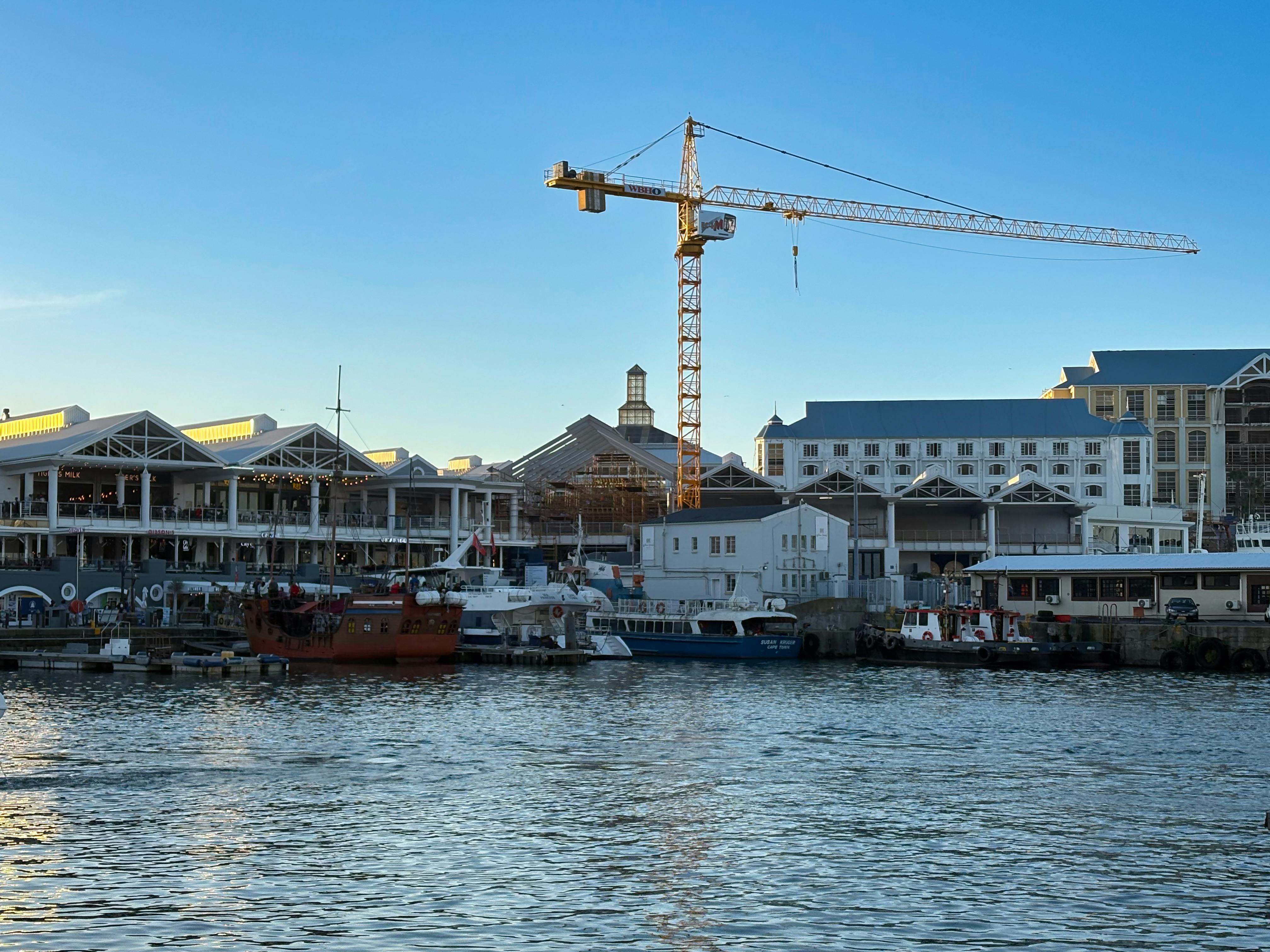 Cape Town limanından gün batımında demir alan tekne